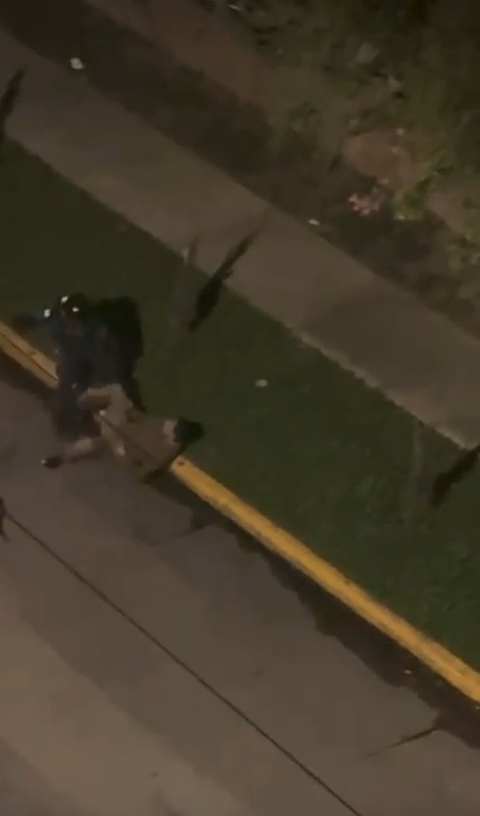 agente policial sometiendo a un ciudadano durante el operativo de desalojo frente al INFOP, en medio de protestas pacíficas en Tegucigalpa.