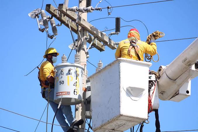 Técnicos electricistas trabajan en infraestructura de distribución eléctrica